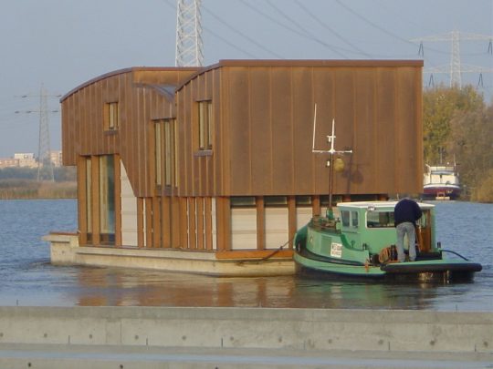 Nieuwbouw woonboot waterwoning in Amsterdam het verslepen naar de ligplaats, het vertrek uit Diemen